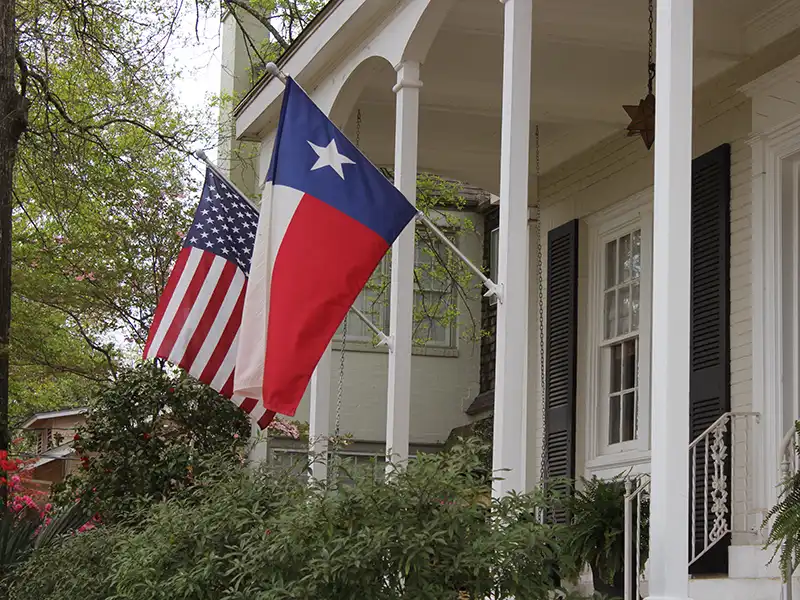American and Texas flag outside home