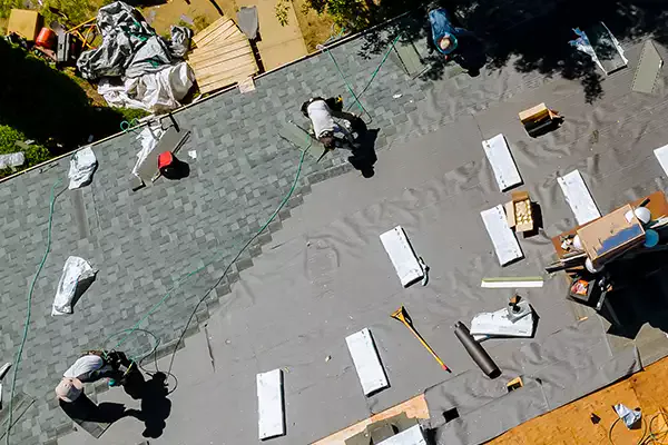 Workers replacing the shingles of a roof